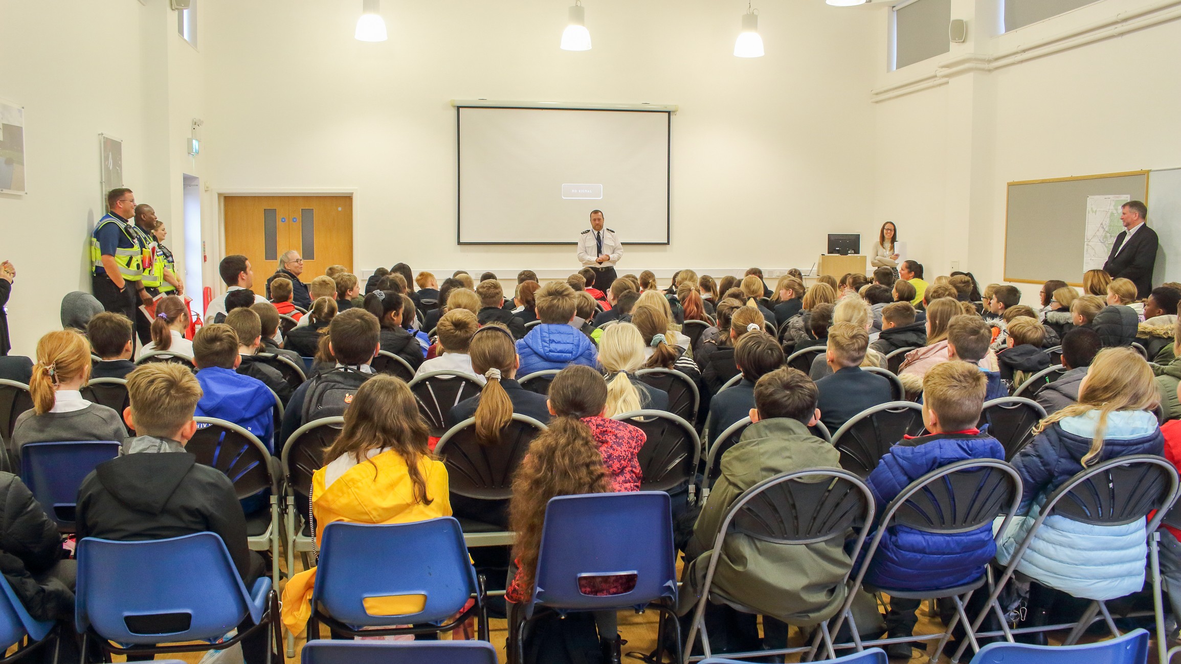 Partners addressing a school assembly